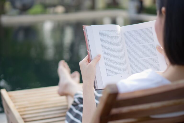 rear-view-woman-reading-book-while-relaxing-lounge-chair-poolside-min Dharamshala